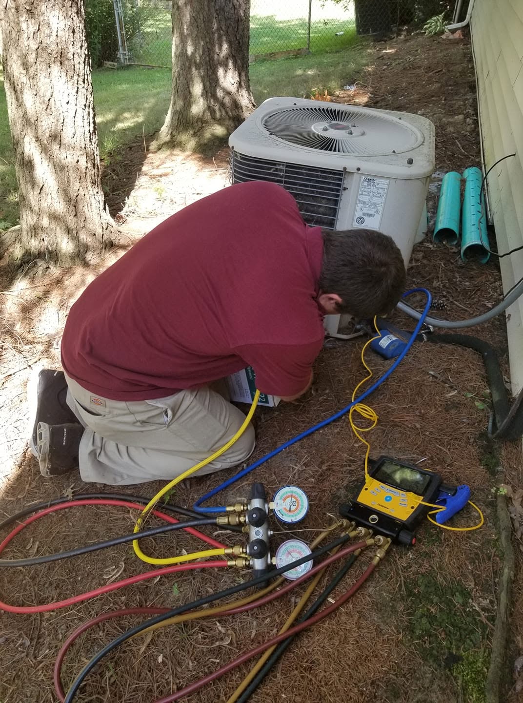 AC Diagnostic with Refrigerant Manifold Gauges — Aurora OH — PDR Comfort Systems PDR Comfort Systems HVAC technician diagnosing a residential outdoor AC condenser with refrigerant manifold gauges for a Aurora, OH homeowner — real Northeast Ohio HVAC service work.